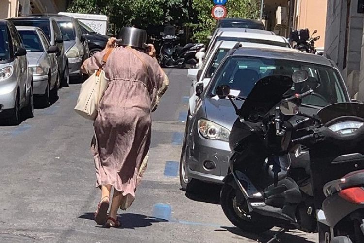 H Viral φωτογραφία της ημέρας: Η γυναίκα στο Κολωνάκι που τρέχει με την κατσαρόλα στο κεφάλι μετά τον σεισμό